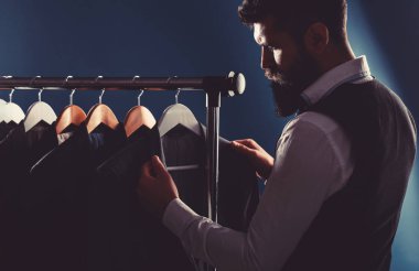 Yeleği, satır uygun dükkanda iş adamı. Bir bez ceketli şık adamı. Bu galeride, poz, kıyafetlere var. Yakışıklı sakallı iş adamı Klasik takım elbise