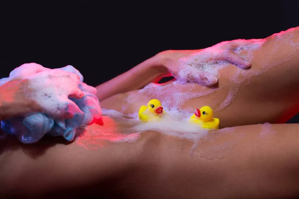 Sensual girl, sexy body, naked woman. Soap foam, shower gel, hot girl. Erotica, beautiful girl washing her body. Sexy girl with ducks and soap foam