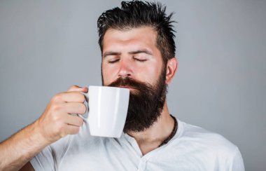 Günaydın, bir fincan çay tutan adam. Sabah kavramı. Yakışıklı sakallı erkek tutar kahve, çay. Taze kahve fincan gülümseyen hipster adam. Sakallı adam gülümsüyor. Portre erkek. Tatlı te