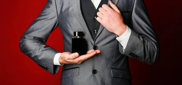 Man perfume, fragrance. Masculine perfume. Perfume or cologne bottle. Male fragrance and perfumery, cosmetics. Bearded man holding up bottle of perfume. Fashion cologne bottle — Stock Photo, Image
