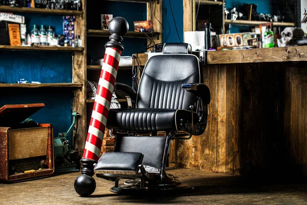Hairstylist in barbershop interior. Barber shop chair. Barbershop armchair, salon, barber shop for men. Barber shop pole. Logo of the barbershop, symbol