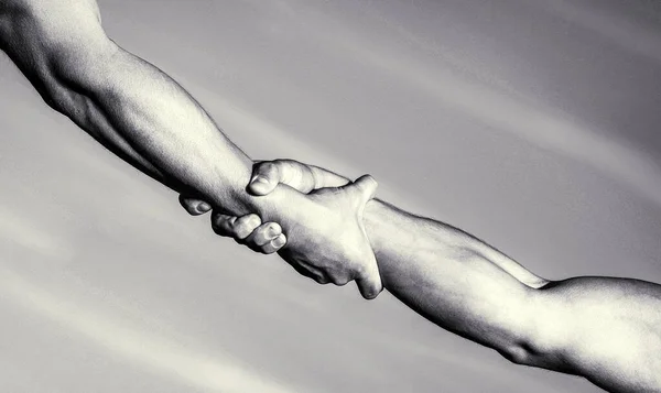 Helping hands concept, support. Helping hand concept and international day of peace, support. Two hands, helping arm of a friend, teamwork. Hands of on blue sky background. Black and white — Stock Photo, Image
