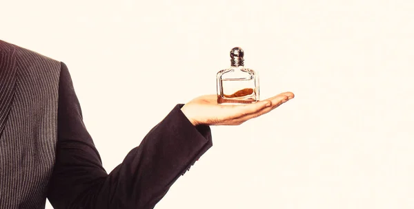 Male holding bottle of perfume, isolated on white background. Perfume or cologne bottle and perfumery, cosmetics, scent cologne bottle, male holding cologne — Stock Photo, Image