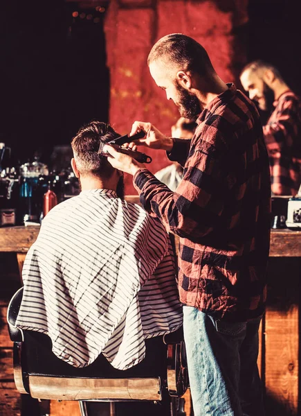 Um cliente Hipster a cortar o cabelo. Mãos de barbeiro com cortador de cabelo. Conceito de corte de cabelo. Hipster cliente recebendo corte de cabelo — Fotografia de Stock