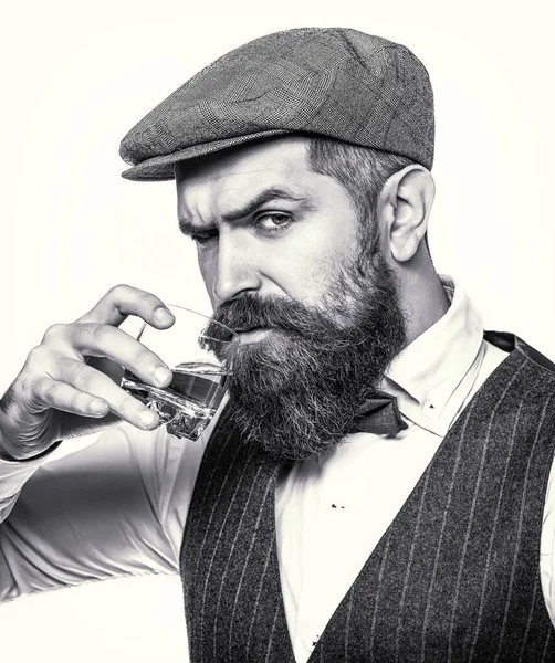 Elinde bir bardak viski tutan bir adam. Kalın sakallı bir adamın portresi. Degukasyon, tatma. Viski yudumluyor. Maço içki. Sakallı adam cam brendi tutuyor. Sakallı konyak. Siyah ve beyaz