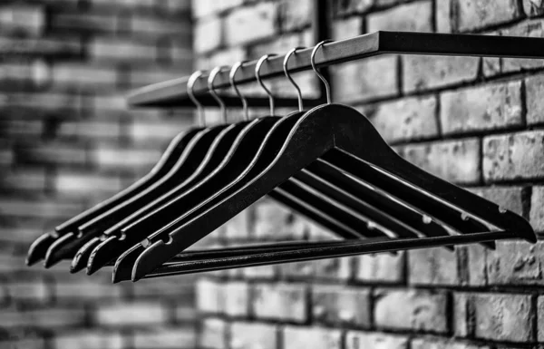 Wooden coat hanger clothes. Fashionable different types of hanger. Many wooden black hangers on a rod. Store concept, sale, design, empty hangers. Black and white — Stock Photo, Image