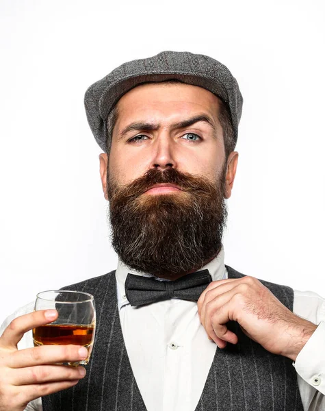 Macho pije. Stylowy bogacz trzymający szklankę starej whisky. Brodaty dżentelmen pije koniak. Łyk najlepszej whisky. Portret mężczyzny z grubą brodą — Zdjęcie stockowe
