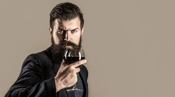 Un homme tenant une coupe de champagne à la main. Homme barbu, barbu, sommelier dégustant du vin rouge. Sommelier, dégustateur avec verre de vin, cave, vigneron masculin. Espace de copie — Photo