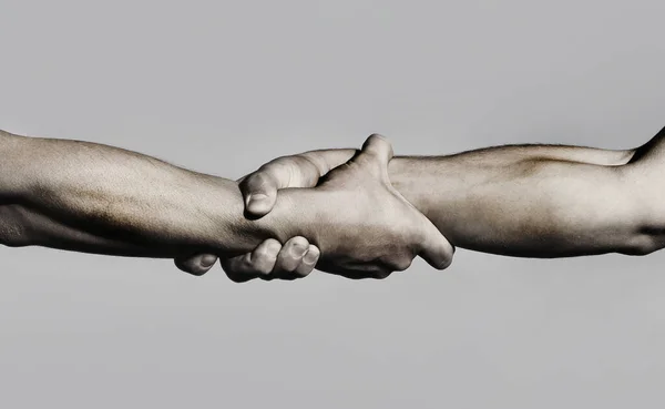 Aperto de mão amigável, cumprimentos amigos, trabalho em equipe, amizade. Close-up. Resgate, ajudando gesto ou mãos. Forte espera. Duas mãos, a ajudar um amigo. aperto de mão, braços, amizade. — Fotografia de Stock