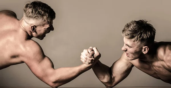 Arm wrestling. Two men arm wrestling. Men measuring forces, arms. Hand wrestling, compete. Rivalry, closeup of male arm wrestling. Hands or arms of man. Muscular hand