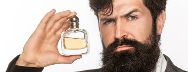 Elinde parfüm şişesi tutan bir erkek. Erkek parfümü, takım elbiseli sakallı bir adam. Parfüm ya da parfüm şişesi, parfüm, kozmetik, parfüm şişesi, kolonya tutan erkek.