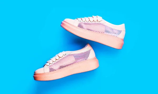 Boven foto van hardloopschoenen. Close-up, moderne sportschoen. Sneakers geïsoleerd op blauwe achtergrond, mode. Sportschoenen. Paar roze sportschoenen op blauwe achtergrond — Stockfoto