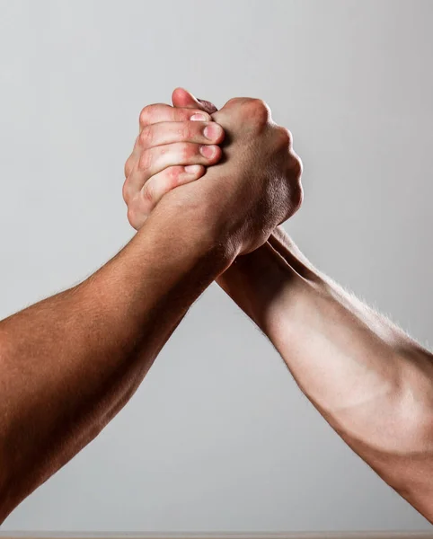 Rivalry, closeup of male arm wrestling. Muscular men measuring forces, arms. Hand wrestling, compete. Hands or arms of man. Muscular hand. Clasped arm wrestling. Two men arm wrestling Stock Picture