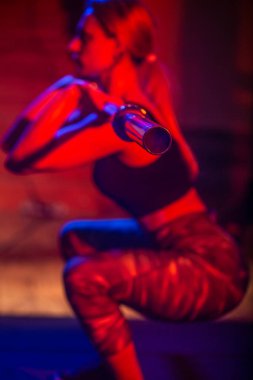 Formda kız spor salonunda halterle çömeliyor. Kadın kas egzersizi yapıyor. Spor, vücut geliştirme, yaşam tarzı konsepti. Halterli spor kadını. Genç bir kadın halter kaldırıyor, spor salonunda çalışıyor.