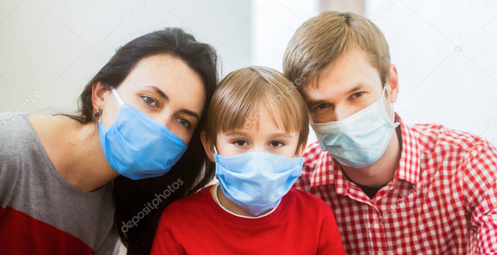 Prevention coronavirus. Stay at home. Coronavirus outbreak. New real life. Young family in safety medical masks. Home quarantine. Coronavirus epidemic. Parents and kid wearing a surgical mask