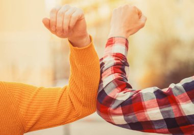 Yakından dirsek çarpması. Dirsek çarpması. Sağlık hizmeti konsepti. Sosyal uzaklık. İki kişi dışarıda koronavirüsten korunmak için dirseklerini vurur. Coronavirüs salgını