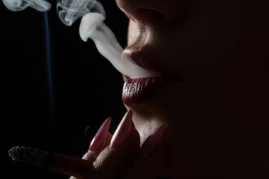 Sigara içiyorum. Dudaklar. Sigara dudaklı. Seksi bir sigara. Seksi bir kadın. Duman girdabı. Duman hareketi. Yakın çekim..