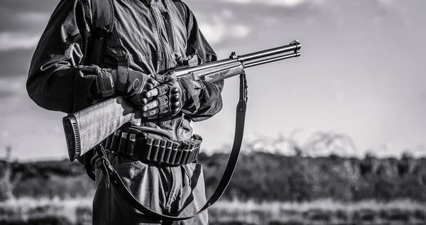 De man is op jacht. Jachtperiode. Man met een pistool. Hunter met rugzak en jachtgeweer. Een jager met een jachtgeweer en jachtformulier om te jagen. Een jager. Zwart-wit — Stockfoto