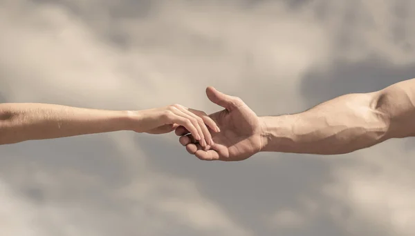 Giving a helping hand. Hands of man and woman on blue sky background. Lending a helping hand. Solidarity, compassion, and charity, rescue — Stock Photo, Image
