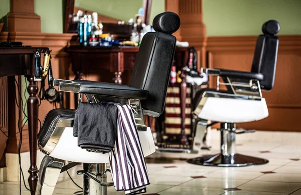 Peluquero profesional en barbería interior. Sillón de peluquería, peluquería moderna y peluquería, peluquería para hombres. Elegante silla de barbero vintage — Foto de Stock
