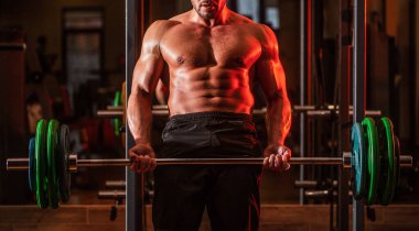 Koltuk değneği egzersizi. Spor salonunda halterle çalışan kaslı bir adam. Vücut geliştirici atletik adam, karın kasları, omuzları, pazıları, kasları, göğsü...