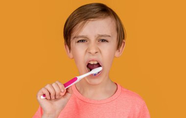 Erkek diş fırçası beyaz diş macunu. Sağlık hizmeti, diş hijyeni. Çocuk diş fırçalarını gösteriyor. Diş temizleyen küçük çocuk. Diş hijyeni. Küçük çocuk dişlerini fırçalıyor. Çocuk dişlerini fırçalıyor..