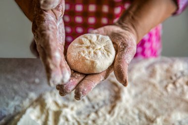Evde pişireceğim. Pişirmek için hamur pişiriyor, çiğ hamur parçaları. Kadınların elleri turta için hamuru yuvarlıyor. Kadınların elinde ev yapımı kek hamuru. Turta yapma süreci, el..
