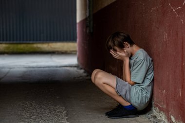 Yalnız bir çocuk tünelde oturuyor. Sokakta yalnız başına oturan üzgün çocuk depresyondan muzdarip. Yüzünü örten korkmuş, küçük bir çocuk. Çocuk bağırıyor, elleriyle yüzünü kapatıyor, zorbalık yapıyor..