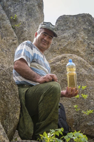 Man Resting Top Mountain Cliff Holding Bottle Cool Drink — Stock Photo, Image