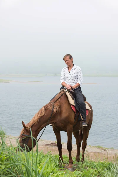 Kvinna Rider Att Uppmuntra Hästen Att Nypa Gräset — Stockfoto
