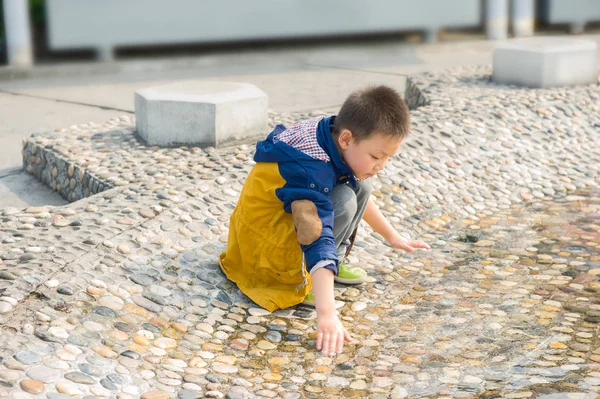 Ichan, provincia di hubei / Cina - 10.28.2013: Bambino che gioca vicino allo stagno (fontana). Ragazzo ama giocare con fontana d'acqua — Foto Stock