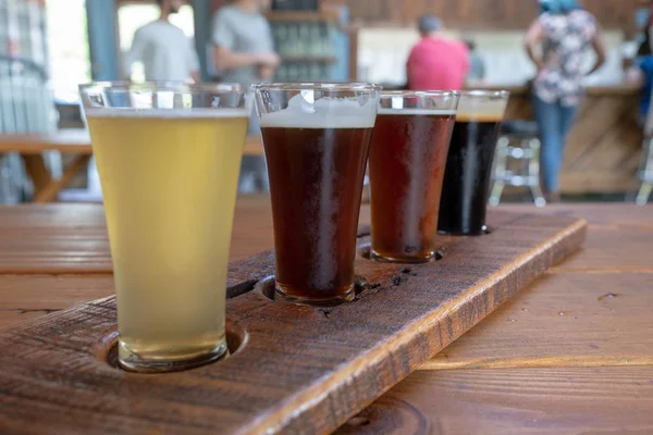 Vôo Quatro Cervejas Servidas Copos Altos Uma Bandeja Madeira — Fotografia de Stock