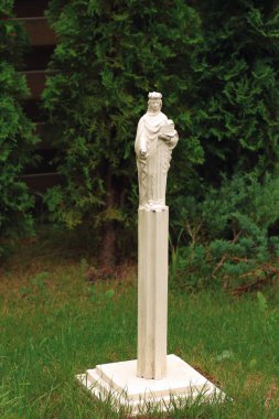Parktaki sütunda küçük beyaz bir kadın heykeli
