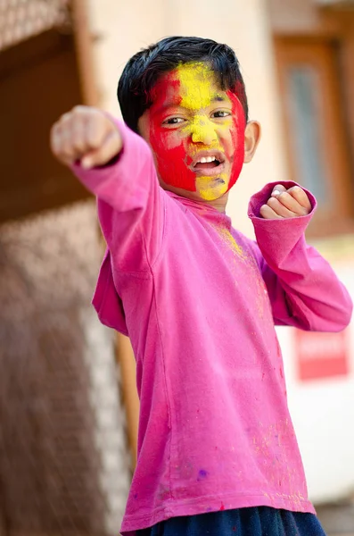 Schattige kleine Indiase jongenskind boksen met gekleurd gezicht tijdens ho — Stockfoto