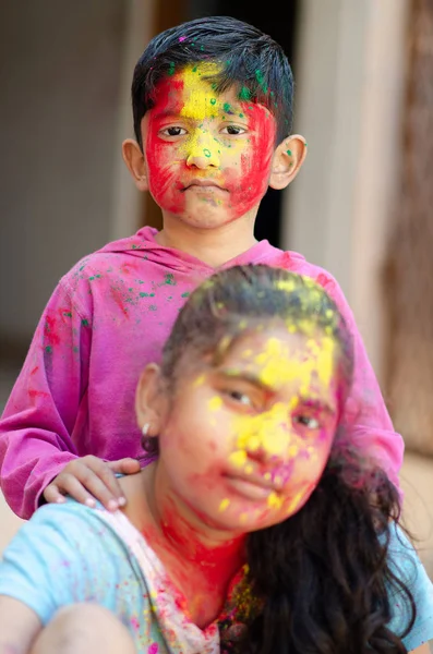Roztomilý rozkošný sourozenci hrát s barvami během holi festival — Stock fotografie