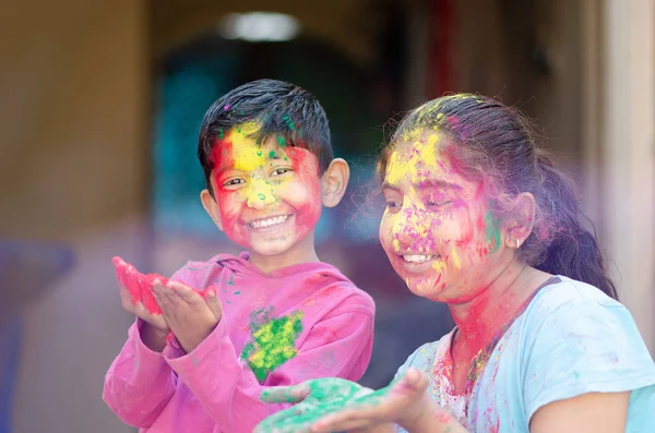 Jolis frères et sœurs adorables jouant avec les couleurs pendant le festival holi — Photo