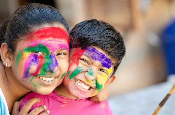 Lindos hermanos adorables jugando con colores durante el festival holi —  Fotos de Stock