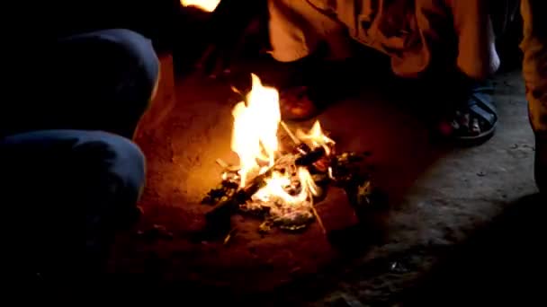 人们坐在火周围热身在冬季夜边看城市场景 — 图库视频影像