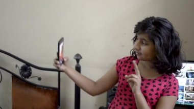 Sevimli şık Hint Asya kafkas mutlu kız çocuk cep telefonu ön görünüm portre somurtkan selfie alarak 