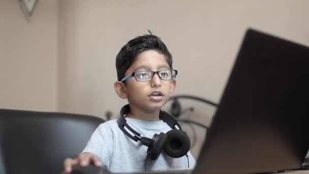インドのアイサン白人オタクの少年は 首にヘッドフォンを着用してラップトップで働いています 音楽愛好家サイドビューの肖像 — ストック動画