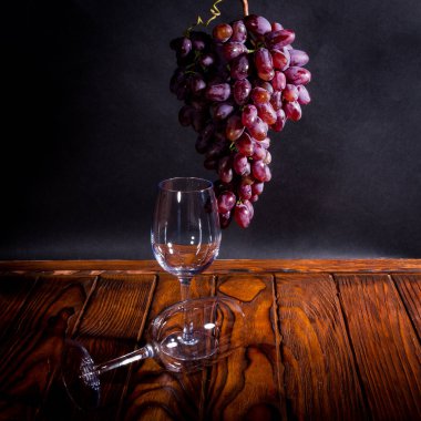 koyu arka plan üzerinde şarap kadehi ile üzüm