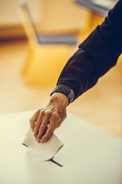 Seçimler sırasında sandık merkezinde oy kullanan bir kişinin renkli görüntüsü.
