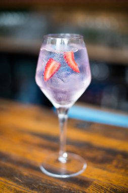 Çilek ile dekore edilmiş bir pembe kokteyl bardak kadar kapatın.