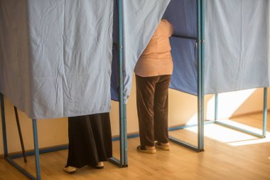 Seçimler sırasında, bir sandık merkezinde oy kullanan tanımlanamayan kişilerin renkli görüntüsü.