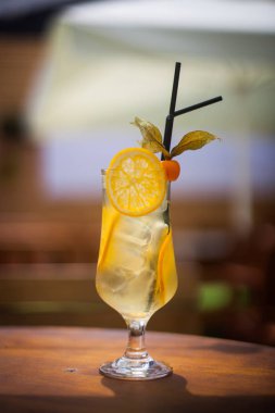 Sarı bir kokteyl bardak limon ile dekore edilmiş kapatmak.