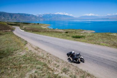 Bir dağ ve göl tarafından desteklenen bir sepet motosiklet.