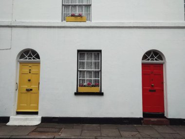 Bir binanın ön cephesindeki iki kapının renkli görüntüsü.