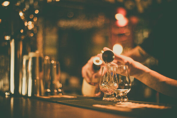 Bartender pouring whisky in a glass