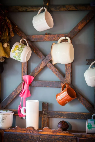 Чашки висят на деревенской кухне — стоковое фото