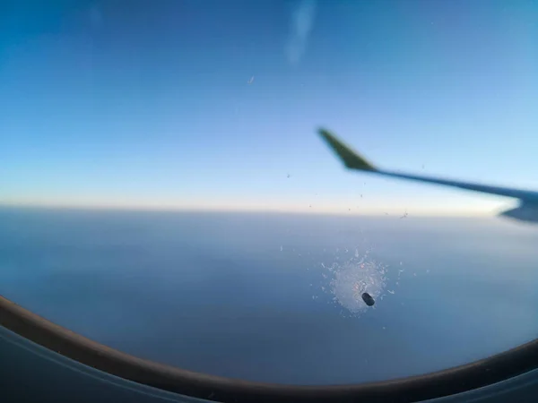 Un pequeño agujero en la ventana de un avión — Foto de Stock